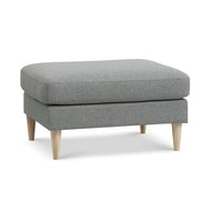Nebraska puf fra Lexpo i lysegrå møbelstof og ben i eg