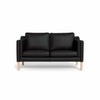Clausholm 2-pers sofa fra Top-Line monteret med sort semianilin læder og ben i egetræ