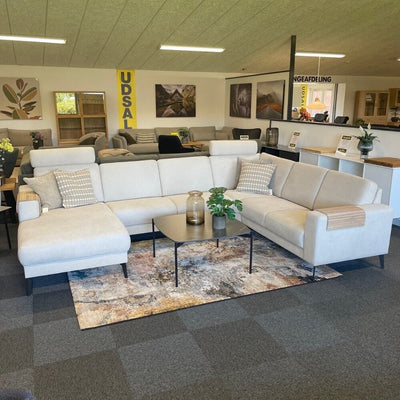 City hjørnesofa fra Hjort Knudsen monteret med slidstærkt ly beige møbelstof og sorte metalben.