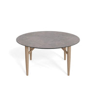 Katrine sofabord fra Thomsen Furniture med stengrå laminat overflade og  ben i massiv egetræ, størrelse Ø 80 cm.